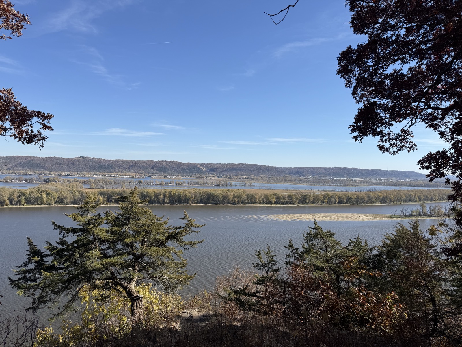 A wide view of the Mississippi River valley from a wooded bluff in Eastern Iowa on a clear autumn day.